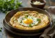 Egg appam pannulla, munalla ja korianterilla koristeltuna