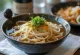 Bukkake udon kylmällä udon-nuudelilla, dashi-liemessä, tuoreilla vihanneksilla